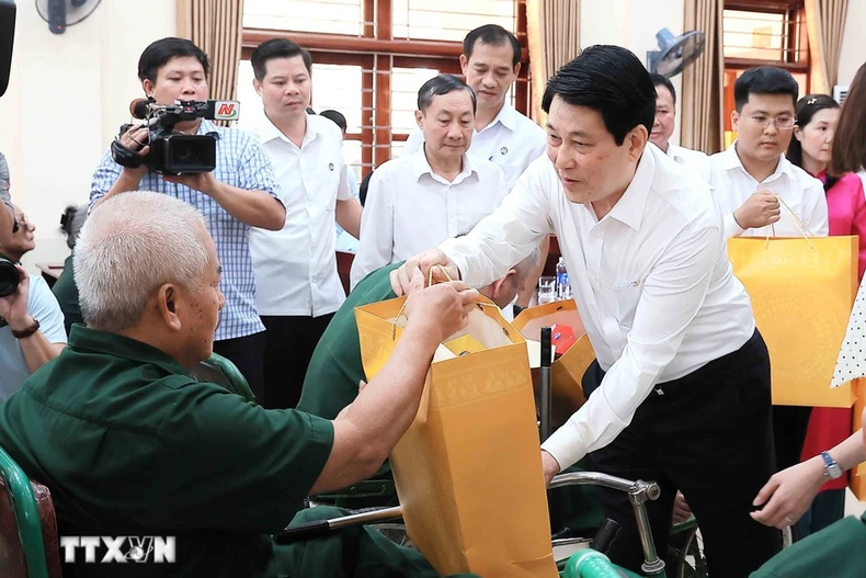El presidente Luong Cuong entrega obsequios a Nguyen Xuan Mai, inválido de guerra, quien recibe tratamiento en el Centro de Rehabilitación de Veteranos de Guerra de Duy Tien. (Foto: VNA)