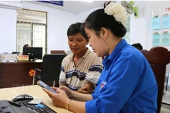 Una jóven de la Unión de Jóvenes Comunistas Ho Chi Minh de la comuna de Tuy An Nam, provincia de Dak Lak, orienta a los residentes sobre cómo completar la información correctamente antes de presentar los documentos para trámites administrativos. Foto: VNA