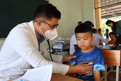 Médicos del centro de salud de la comuna de Hung Phuoc examinan a niños. (Foto: VNA)