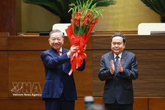 El presidente de la Asamblea Nacional, Tran Thanh Man, entrega flores para felicitar al secretario general y presidente To Lam. (Foto: VNA)