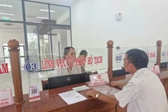 Las personas hacen trámites administrativos en el día del inicio de la prueba del gobierno de dos niveles en el distrito de Pleiku, Gia Lai. (Fuente: VNA)
