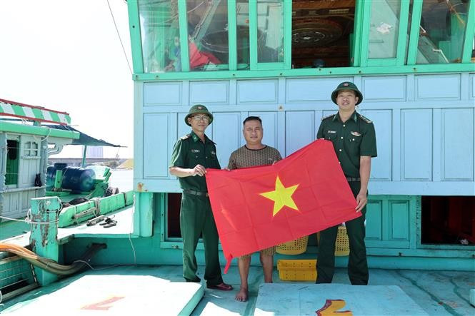 Oficiales y soldados de la Estación de Guardia Fronteriza de Son Tra (Comando de la Guardia Fronteriza de la ciudad de Da Nang) entregaron banderas nacionales a los pescadores. (Fuente: VNA)