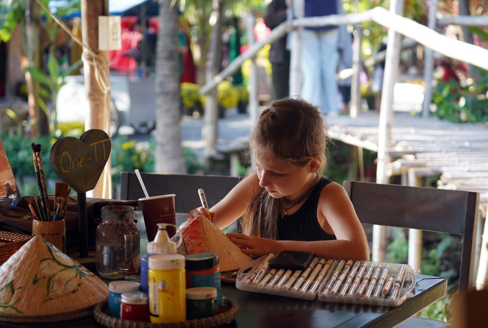 Niños extranjeros escriben caligrafía en un espacio dedicado a las tradicionales celebraciones del Tet en el pasado. (Fuente: VNA)