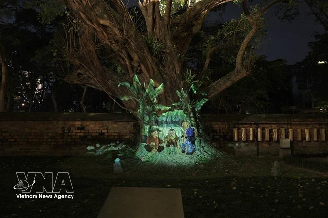 Bajo la luz y el movimiento, el viejo tronco del árbol narra historias ancestrales usando la tecnología. (Foto: VNA)