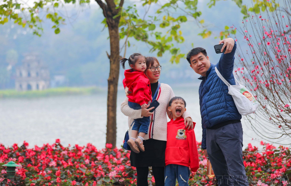 Una familia grabó momentos de la primavera cerca del lago Hoan Kiem (enero de 2023). (Fuente: VNA)