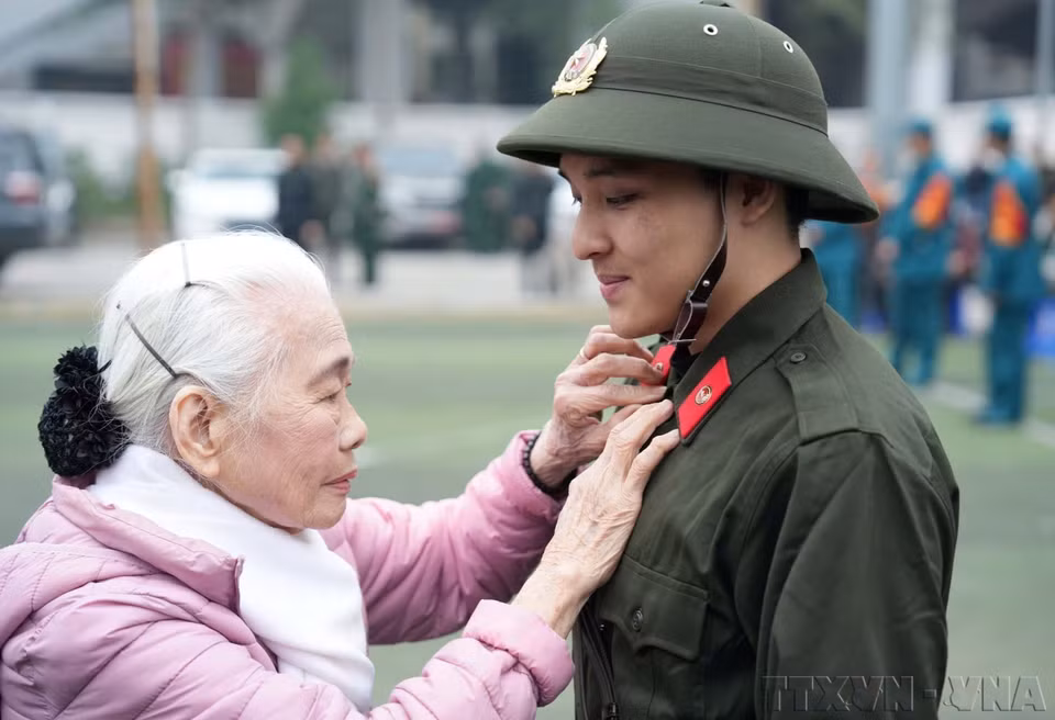 La señora Nguyen Thi Minh Thuan, de 90 años de edad, despide a su nieto cuando se va a cumplir con su deber de seguridad pública en el distrito de Dong Da, Hanoi (febrero de 2025). (Fuente: VNA)