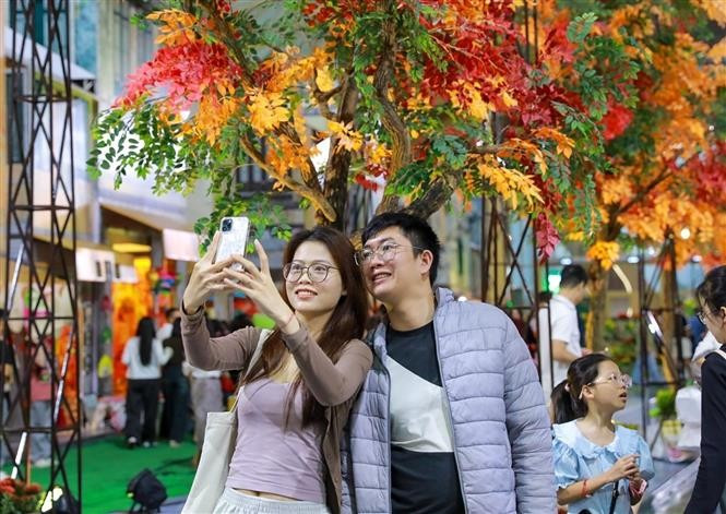 El público se toma fotos en la "Calle de otoño de Hanoi". (Fuente: VNA)