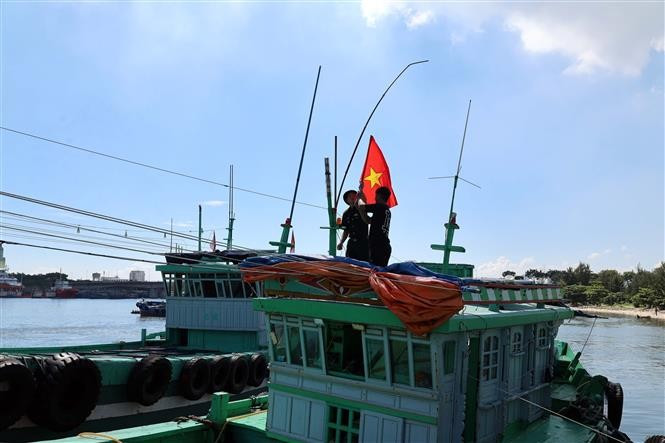 Oficiales y soldados de la Estación de Guardia Fronteriza de Son Tra (Comando de la Guardia Fronteriza de la ciudad de Da Nang) entregaron banderas nacionales a los pescadores. (Fuente: VNA)