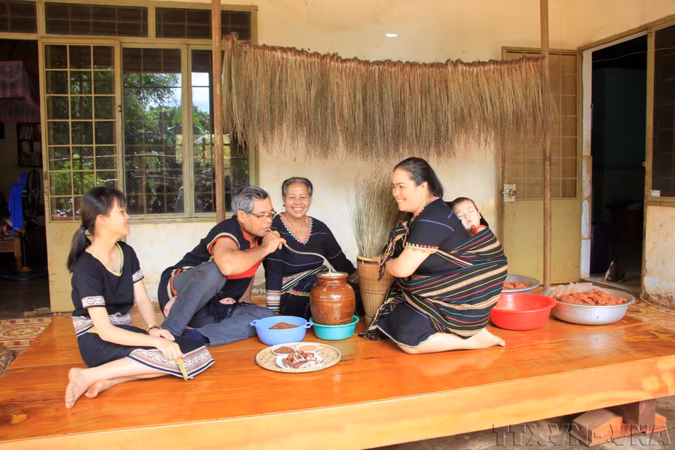 Una familia de Tay Nguyen (Altiplanicie Occidental) se reúne para disfrutar de platos tradicionales y beber vino de arroz. (Fuente: VNA)