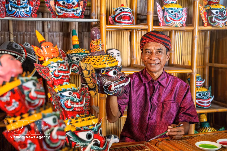 El distinguido artesano Kim Manh, de 62 años, de la comuna de Ta Cu, provincia de Vinh Long, elabora una máscara tradicional para la danza del demonio. (Fuente: VNA)