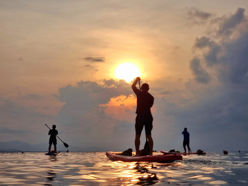 Los turistas remando en botes en la playa de Binh Son (ciudad de Phan Rang - Thap Cham) dan la bienvenida al amanecer en el vasto mar. (Fuente: VNA)