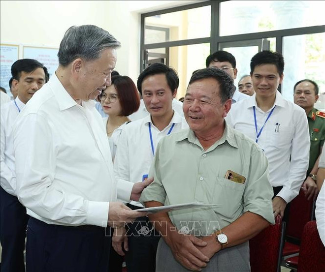 El secretario general del Partido Comunista de Vietnam, To Lam (izq.), conversa con residentes locales en el Centro de Servicios de Administración Pública de la comuna de Phuc Thinh. (Foto: VNA) hinh-anh-9.jpg