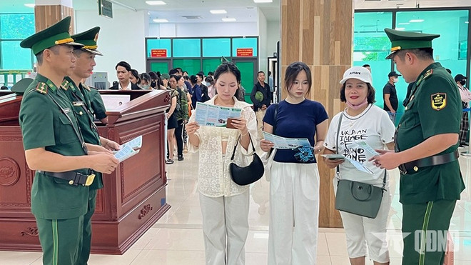 Oficiales vietnamitas distribuyen folletos a los pasajeros que cruzan por la puerta fronteriza. (Foto: qdnd.vn) tuyen-truyen.jpg