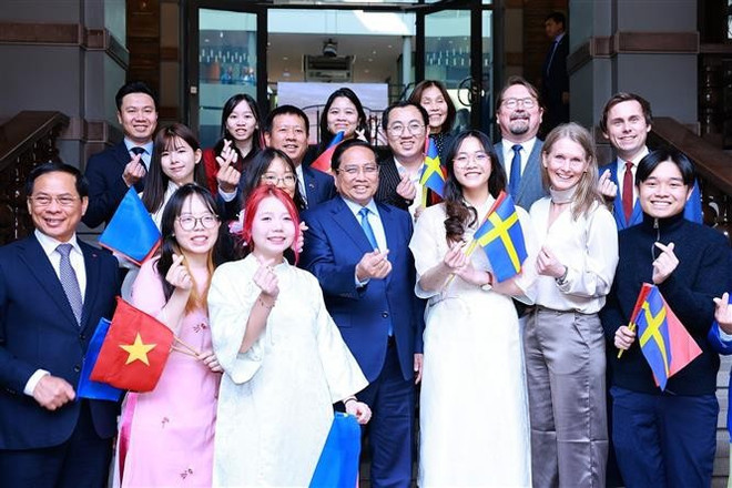 El primer ministro Pham Minh Chinh junto con algunos delegados y los alumnos vietnamitas que estudian en la Escuela de Economía de Estocolmo (Foto: VNA) vna-potal-thu-tuong-phat-bieu-ve-chinh-sach-tai-dai-hoc-kinh-te-stockholm-8088071.jpg