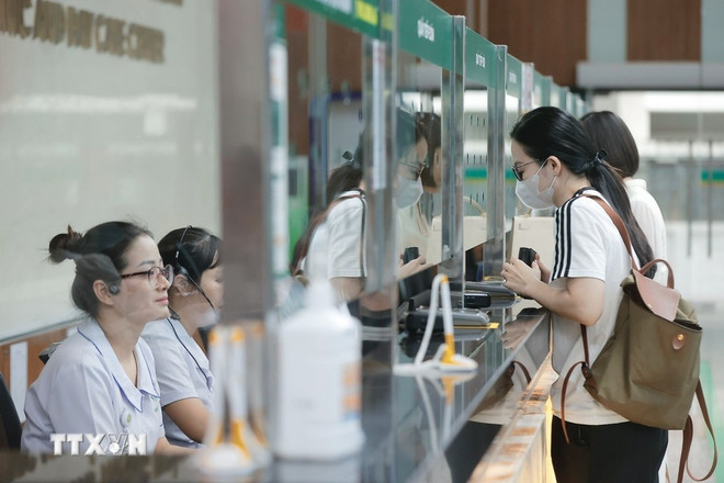 Las personas que acuden a una consulta médica se registran en la recepción. (Foto: VNA) kham-benh.jpg