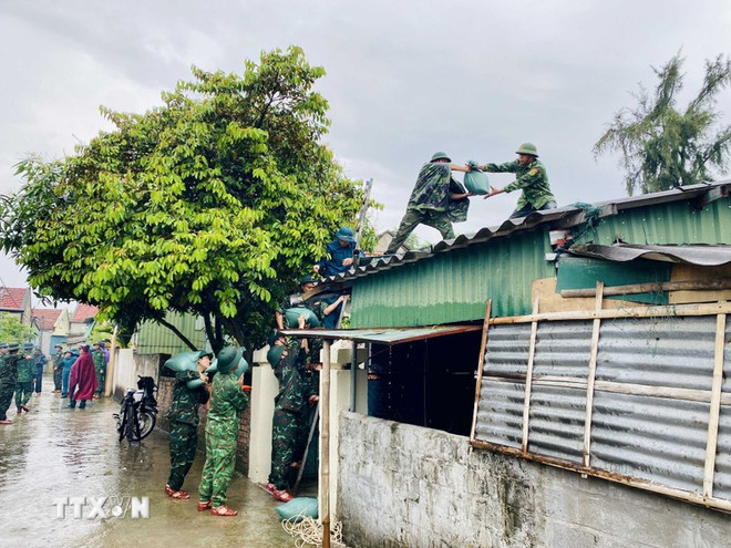 Los militares refuerzan los techos de los pobladores de la comuna de Dan Hai, Ha Tinh (Foto: VNA) luc-luong-quan-doi-ho-tro-nguoi-dan-ha-tinh-ung-pho-bao-so-3-8162182.jpg