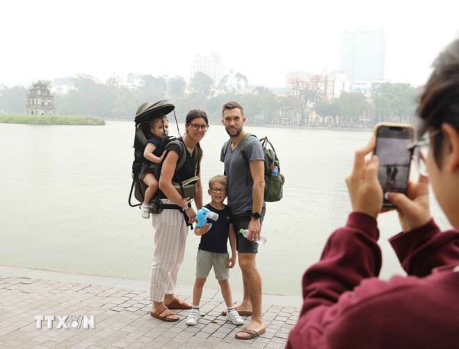 Turistas extranjeros en el lago Hoan Kiem, Hanoi (Foto: VNA) 0306-du-lich-ha-noi-1.jpg