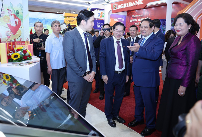 El primer ministro de Vietnam, Pham Minh Chinh, visita una exposición de productos, servicios y aplicaciones de transformación digital para las actividades bancarias. (Foto: VNA) vna-potal-thu-tuong-du-su-kien-chuyen-doi-so-nganh-ngan-hang-nam-2025-8062206.jpg