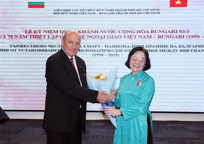 La presidenta de la Asociación de Amistad Vietnam-Bulgaria de Ciudad Ho Chi Minh, Hoang Thai Lan (derecha), entrega flores de felicitación al consejero económico y comercial búlgaro en la urbe, Oleg Marinov, durante la ceremonia. (Foto: VNA) friendship-union-celebrates-bulgarias-national-day-in-hcm-city.jpg