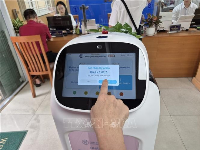 El robot ayuda a las personas a realizar sus procedimientos con más facilidad (Foto: VNA) hanhchinh-cong11.jpg