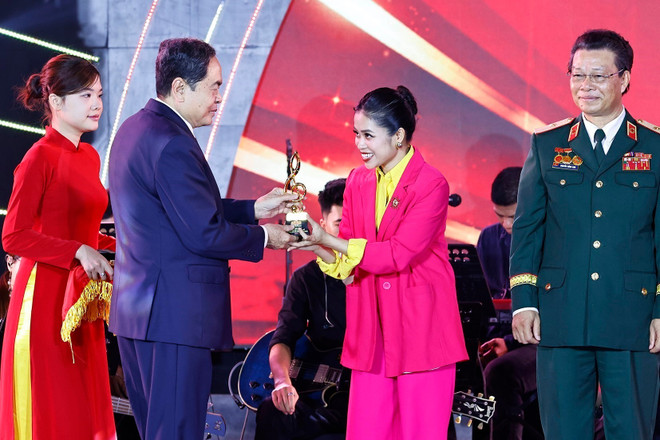 El presidente de la AN, Tran Thanh Man, presenta el trofeo a un autor. (Foto: VNA) vna-potal-le-tong-ket-va-trao-giai-cuoc-van-dong-sang-tac-ca-khuc-ve-quoc-hoi-va-hoi-dong-nhan-dan-8116118.jpg