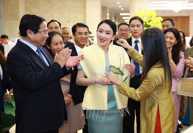 Artesanos vietnamitas presentan productos tradicionales bordados a mano a la primera ministra tailandesa, Paetongtarn Shinawatra. (Foto: VNA) vna-potal-hai-thu-tuong-viet-nam-va-thai-lan-tham-quan-trung-bay-anh-va-cac-san-pham-thu-cong-truyen-thong-8034566.jpg