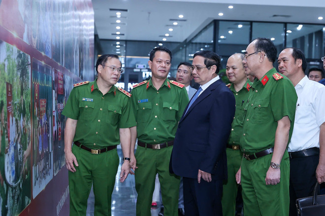 El primer ministro Pham Minh Chinh mira las fotos que resaltan la labor de identificación de los mártires sin nombre. (Foto: VNA) vna-potal-thu-tuong-du-hoi-nghi-so-ket-cong-tac-thu-nhan-mau-adn-cho-than-nhan-liet-si-chua-xac-dinh-duoc-danh-tinh-8172003.jpg