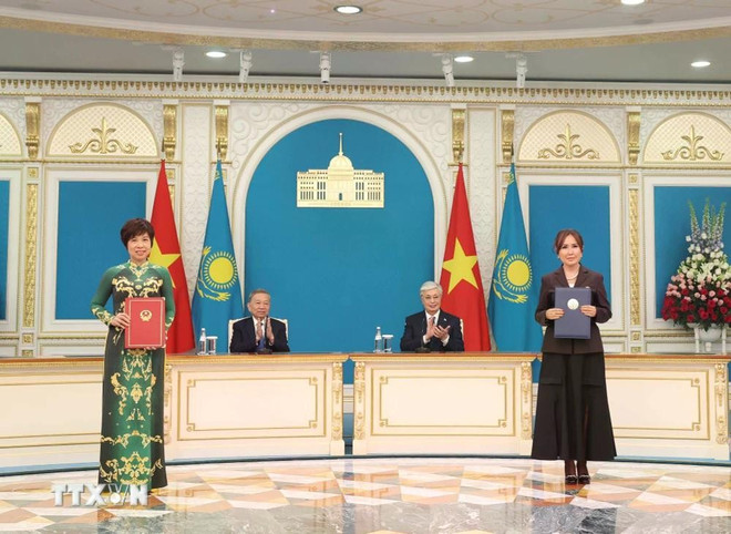 La Agencia Vietnamita de Noticias (VNA) y el Complejo de Televisión y Radio (TRC) del Presidente de Kazajistán intercambian un documento de cooperación. (Foto: VNA) tong-bi-thu-to-lam-va-tong-thong-kazakhstan-chung-kien-le-trao-cac-van-kien-hop-tac-giua-hai-nuoc-06-1.jpg