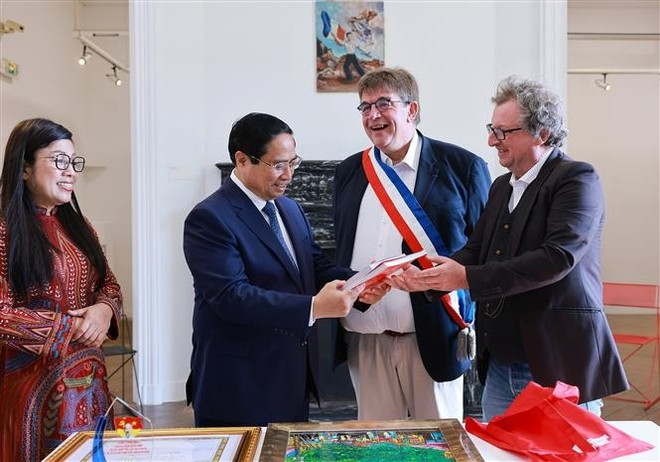 Los representantes del Museo de Historia Viva de Montreuil regalan al primer ministro Pham Minh Chinh y su esposa libros sobre el Presidente Ho Chi Minh (Foto. VNA) vna-potal-thu-tuong-dang-hoa-tuong-niem-chu-tich-ho-chi-minh-tai-thanh-pho-montreuil-phap-8085690.jpg