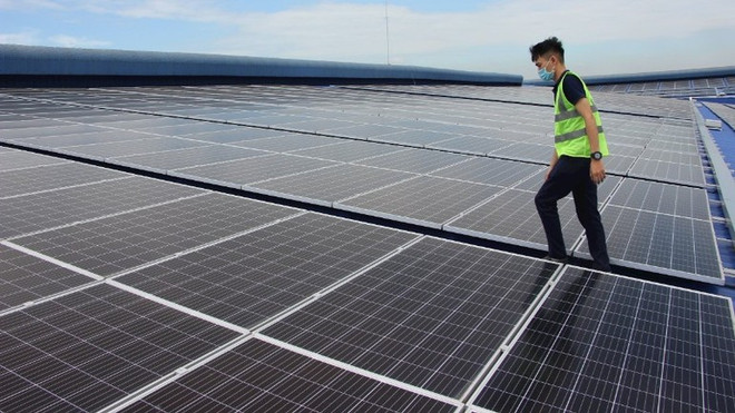 Una empresa en el barrio de Binh Tan, Ciudad Ho Chi Minh, instala un sistema de energía solar en su tejado para cubrir sus necesidades diarias de producción. (Foto: nhandan.vn) image-1.jpg