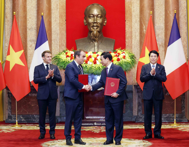 Intercambio de una carta de intención para mejorar la cooperación en el campo de los equipos de defensa (Foto: VNA) vna-potal-chu-tich-nuoc-luong-cuong-va-tong-thong-phap-emmanuel-macron-chung-kien-le-trao-van-kien-hop-tac-8054755.jpg