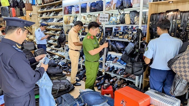 Las autoridades funcionales de la provincia de An Giang inspeccionan e incautan una gran cantidad de productos de origen desconocido en una tienda de la ciudad de Long Xuyen. (Foto: VNA) chong-buon-lau-hang-gia-2.jpg