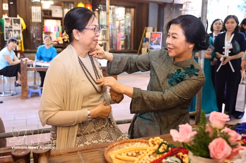 Las primeras damas de Vietnam, Ngo Phuong Ly (derecha), y de Myanmar, Kyu Kyu Hla, en la aldea de seda Van Phuc. (Foto: VNA)