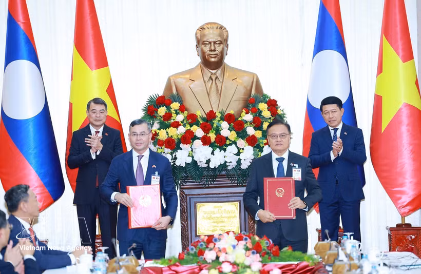 El primer ministro vietnamita, Le Minh Hung, y su homólogo laosiano, Saleumxay Kommasith, presencian la firma del acuerdo de cooperación entre ambos gobiernos en el sector financiero. (Foto: VNA)