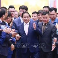 El primer ministro Pham Minh Chinh con empresas que asisten a un seminario sobre desarrollo del sector privado. (Foto: VNA)