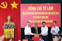 El secretario general To Lam (izquierda) entrega una estatua del Presidente Ho Chi Minh a la comuna de Dat Mui, provincia de Ca Mau. (Foto: VNA)