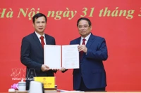 El primer ministro Pham Minh Chinh (derecha) entrega la decisión de nombramiento de Bui The Duy como director de la Universidad Nacional de Hanoi. (Foto: VNA)