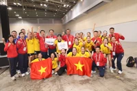 Las jugadoras y el cuerpo técnico de la selección femenina vietnamita de balonmano celebran su medalla de oro. (Foto: VNA)