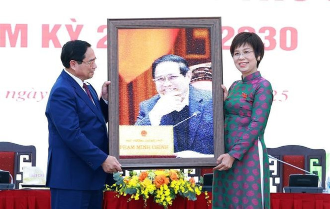 La directora general de la VNA, Vu Viet Trang, entrega una fotografía conmemorativa al primer ministro Pham Minh Chinh. (Foto: VNA) vna-potal-thu-tuong-du-dai-hoi-dang-bo-thong-tan-xa-viet-nam-lan-thu-27-nhiem-ky-2025-2030-8154092-1.jpg