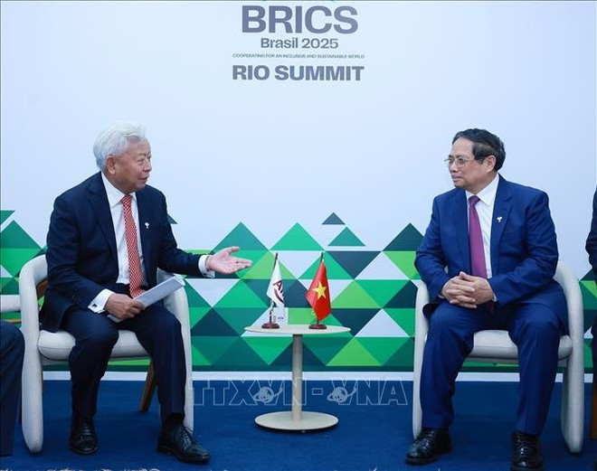 El primer ministro de Vietnam, Pham Minh Chinh, y el presidente del AIIB, Jin Liqun. (Fuente: VNA) vna-potal-thu-tuong-gap-chu-tich-ngan-hang-dau-tu-co-so-ha-tang-chau-a-stand.jpg