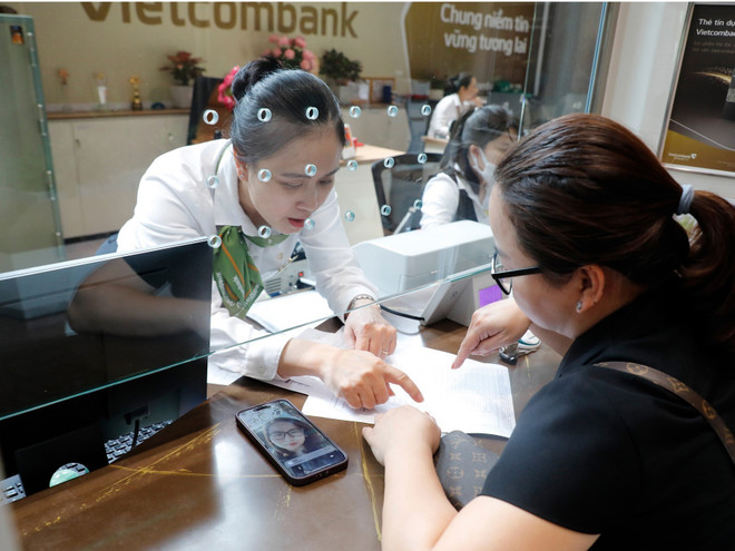 Una cliente realiza transacción en Vietcombank. (Foto: VNA) vna-potal-on-dinh-lai-suat-tien-gui-giam-lai-suat-cho-vay-cho-muc-tieu-tang-truong-kinh-te-2025-8198650.jpg