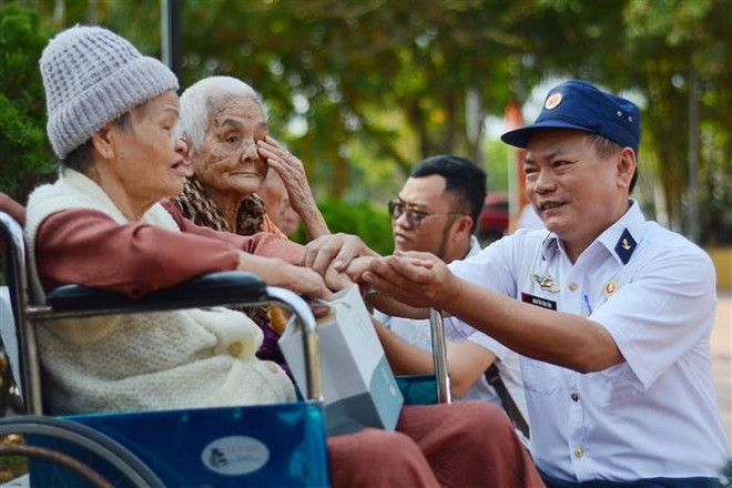 Veteranos de guerra conversan con familiares de soldados caídos en la batalla de Gac Ma. (Fuente: VNA) thumbstand-7.jpg