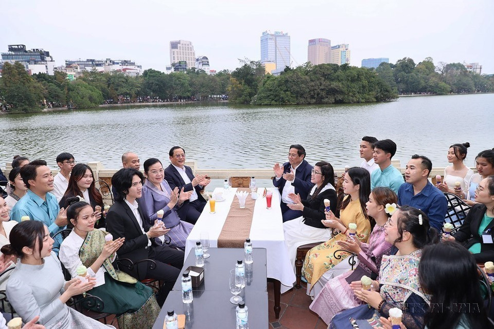 El primer ministro Pham Minh Chinh y su esposa, el premier Sonexay Siphandone y su esposa, junto con los estudiantes, cantaron la canción de solidaridad entre Vietnam y Laos en el espacio cultural e histórico del lago Hoan Kiem (7 de enero de 2024). (Foto: VNA)