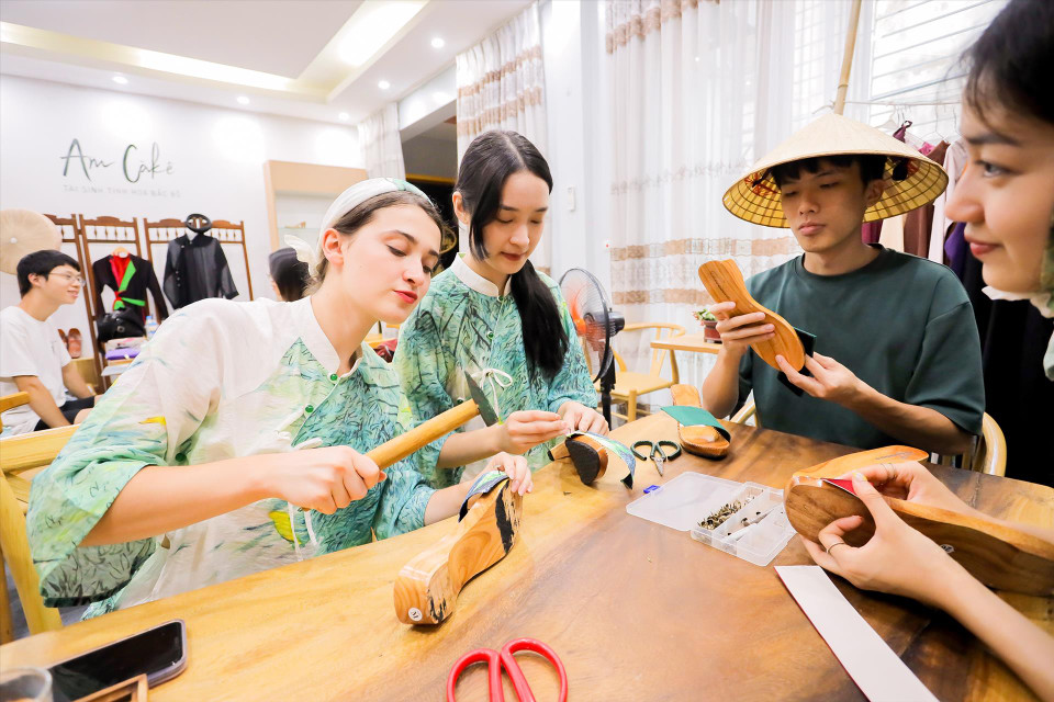Turistas extranjeros experimentan la fabricación de zuecos de madera vietnamitas. (Fuente: Revista Vietnam)