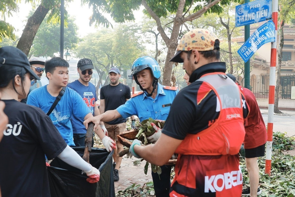 Voluntarios extranjeros se unen a las fuerzas de limpieza y saneamiento ambiental en el distrito de Hoan Kiem. (Foto: VNA)