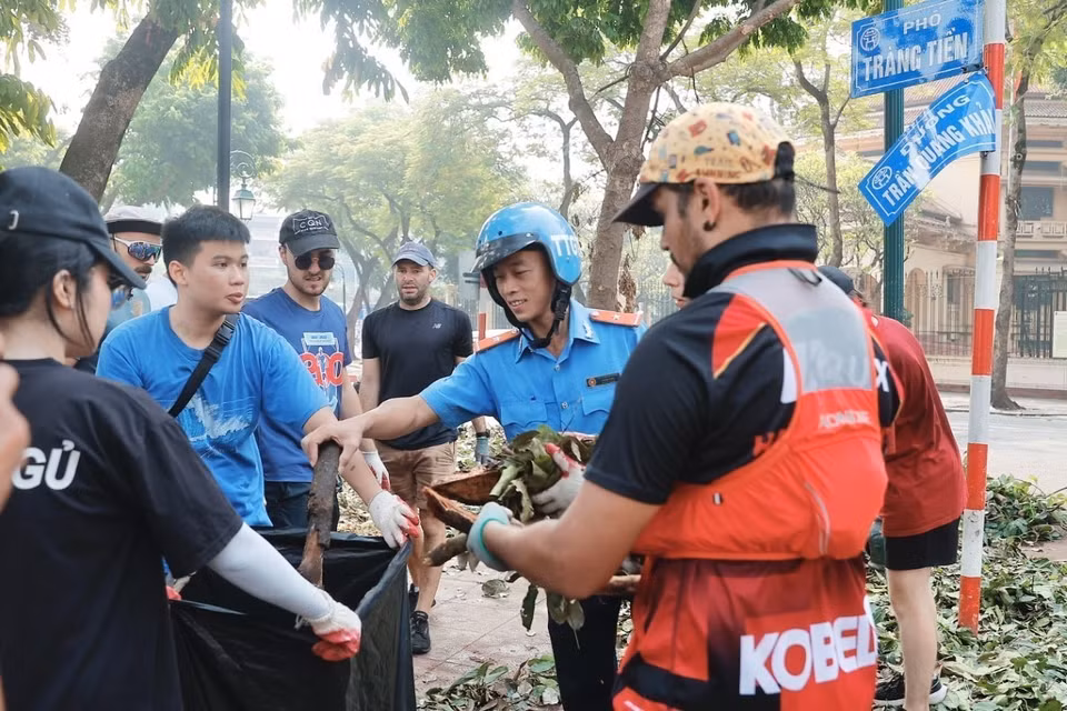 Voluntarios extranjeros se unen a las fuerzas de limpieza y saneamiento ambiental en el distrito de Hoan Kiem. (Foto: VNA)