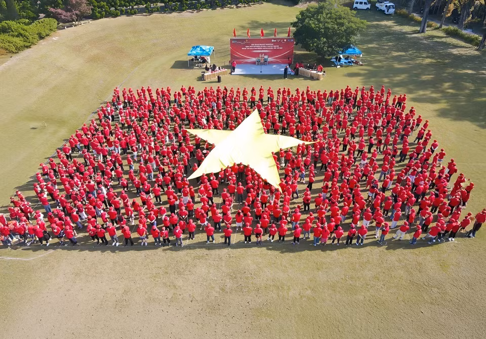 Imagen de la bandera de Vietnam formada por 15 bloques que representan a 15 componentes de la comunidad, con más de 1.000 participantes. (Foto: VNA)