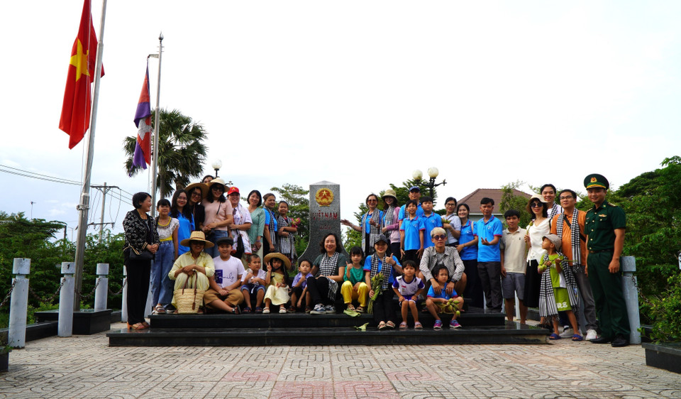 Antes de vivir la experiencia en los campos inundados, los turistas visitan y toman fotos conmemorativas en el hito fronterizo nacional del Paso Internacional de Thuong Phuoc (comuna de Thuong Phuoc). (Foto: VNA)