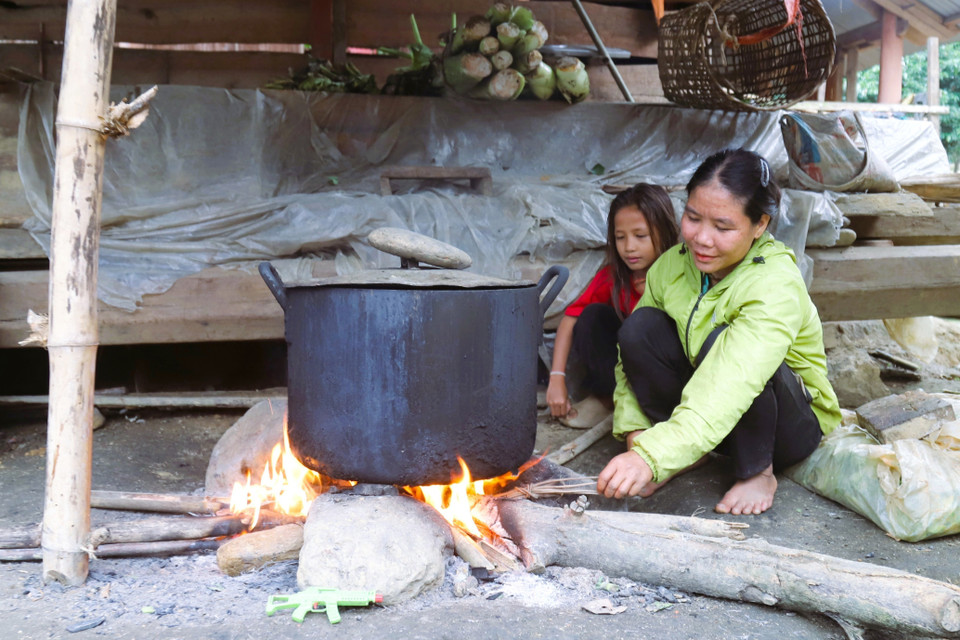 Una mujer de la etnia Dan Lai en la aldea Bung (comuna de Mon Son, provincia de Nghe An) cocinando junto a su hija en el fogón de su casa. (Foto: VNA)