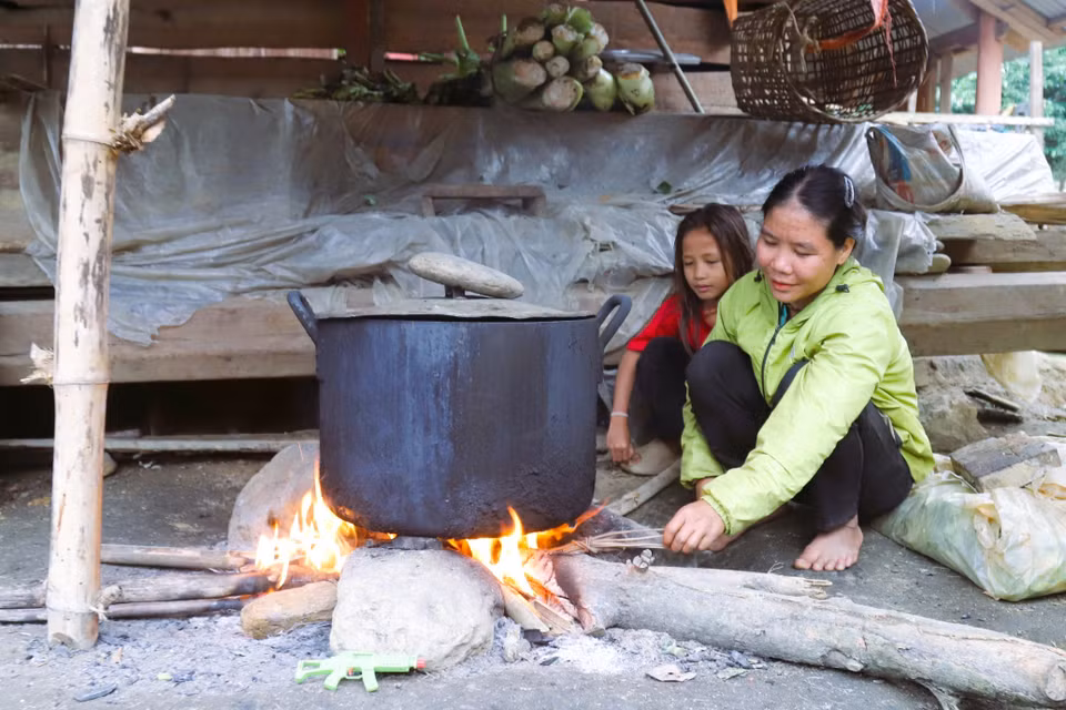 Una mujer de la etnia Dan Lai en la aldea Bung (comuna de Mon Son, provincia de Nghe An) cocinando junto a su hija en el fogón de su casa. (Foto: VNA)
